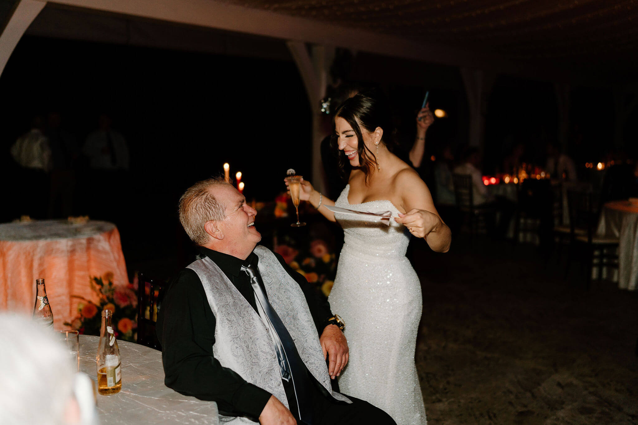 bride fanning her father during wedding reception and laughing