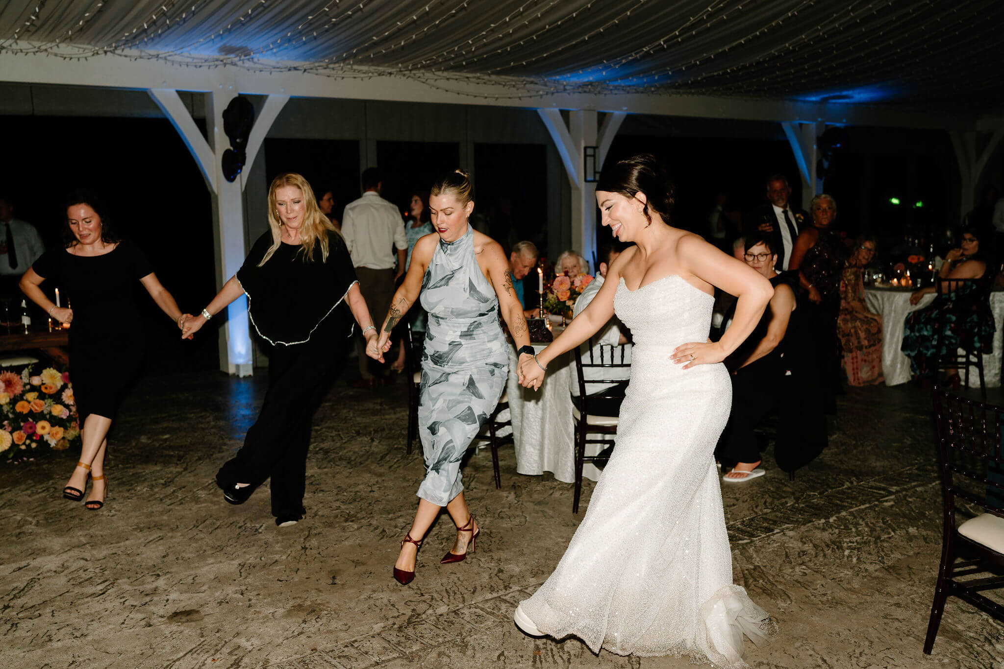 bride and guests dancing during wedding reception