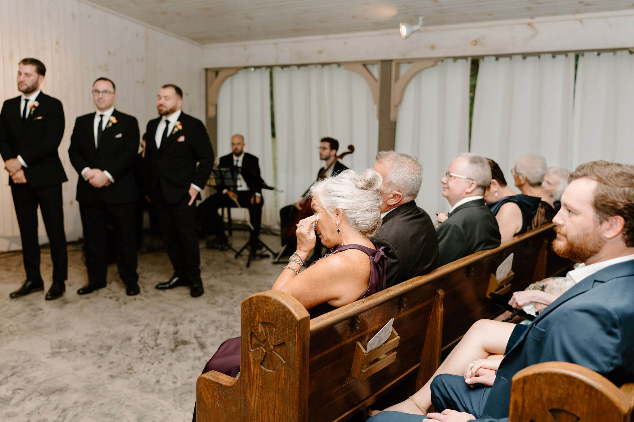 mother of the groom wiping her tears during son's wedding ceremony