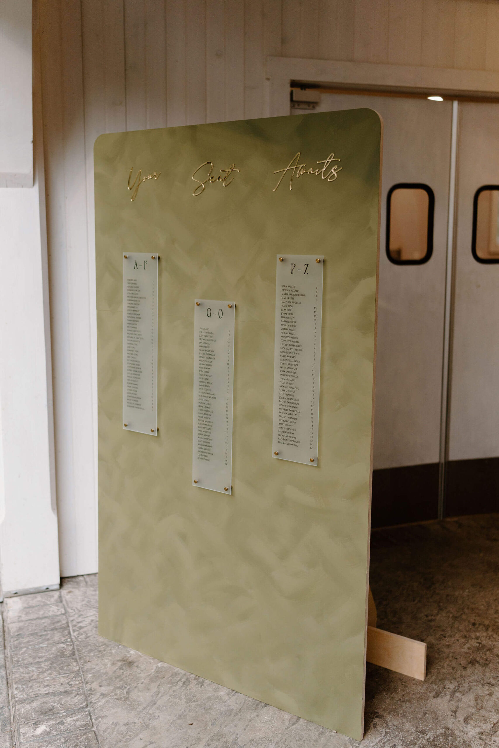 green seating chart with gold decals reading "your seat awaits"