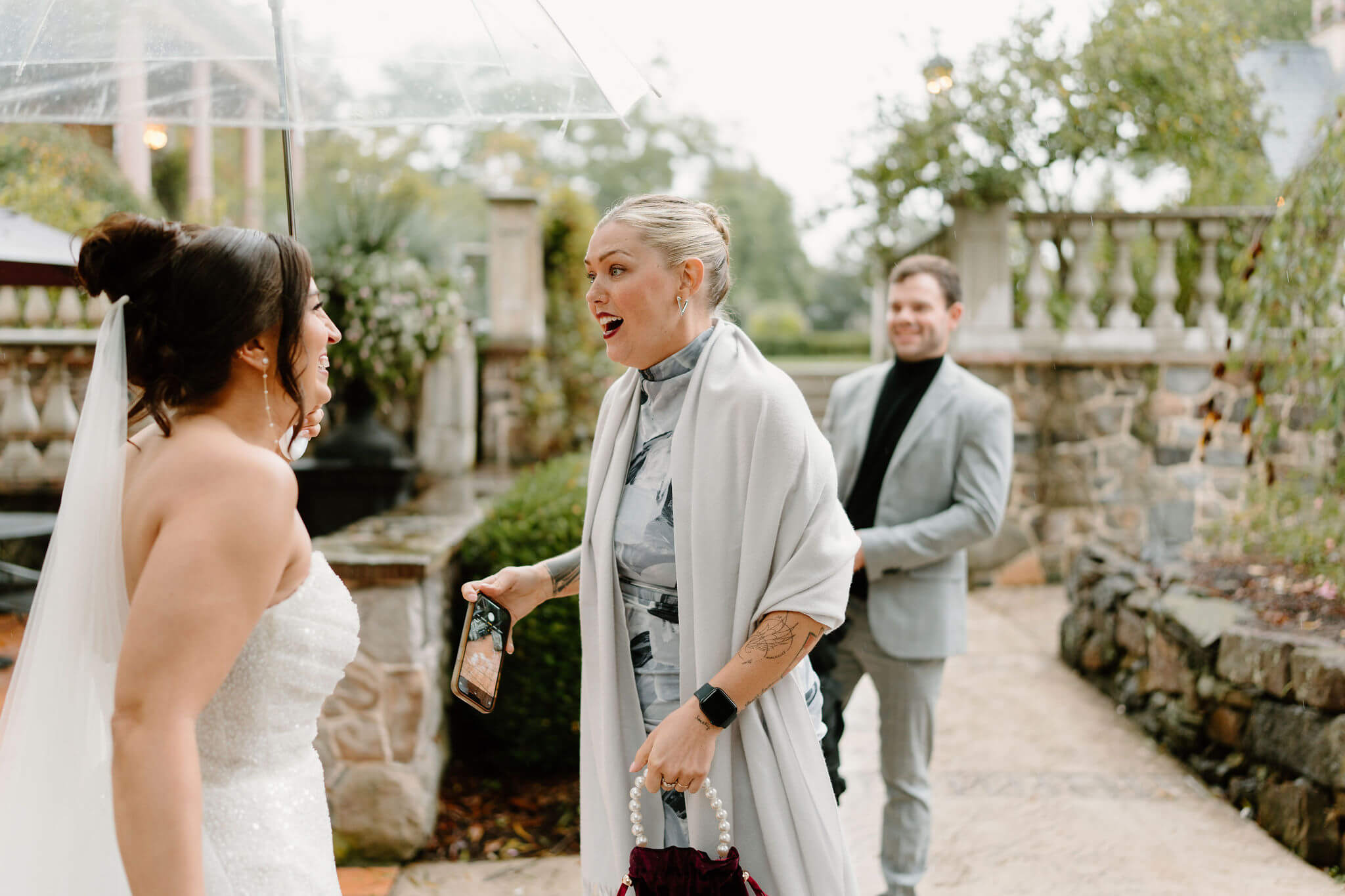 bride seeing guests for the first time during cocktail hour, all smiling