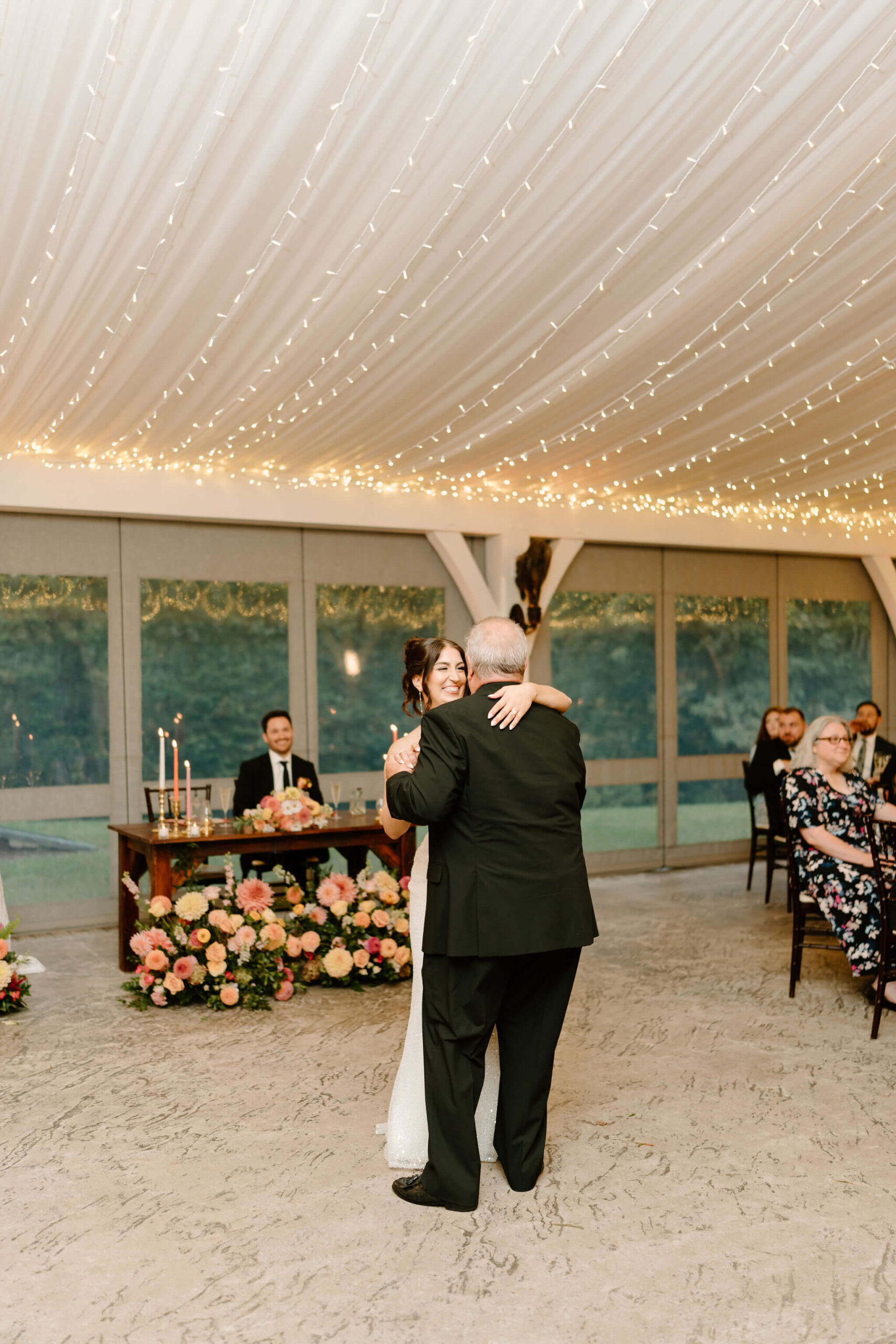 bride and her father laughing and smiling during the father/daughter dance at her wedding reception