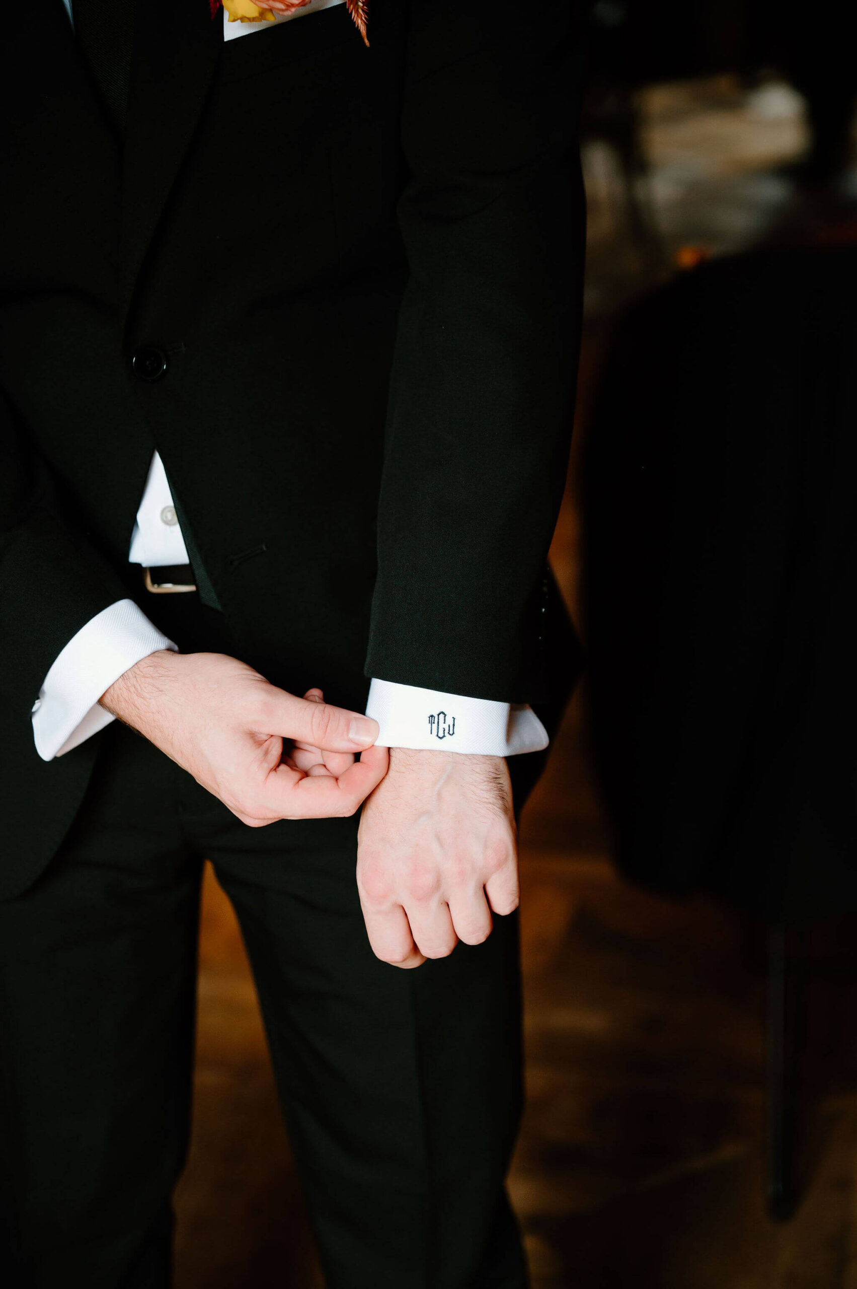 close up image of the cuffs of a dress shirt, custom embroidered with the groom's initials "TJC"