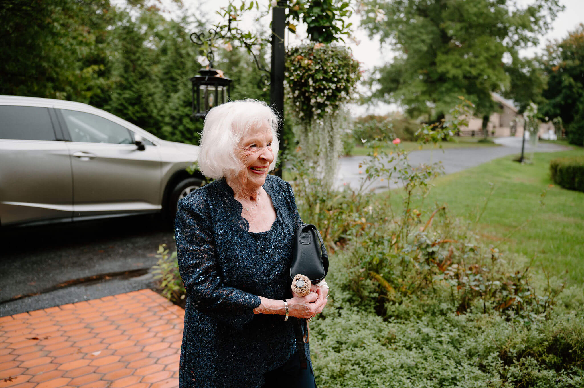 a grandparent in a sparkling navy blue outfit arriving with a smile