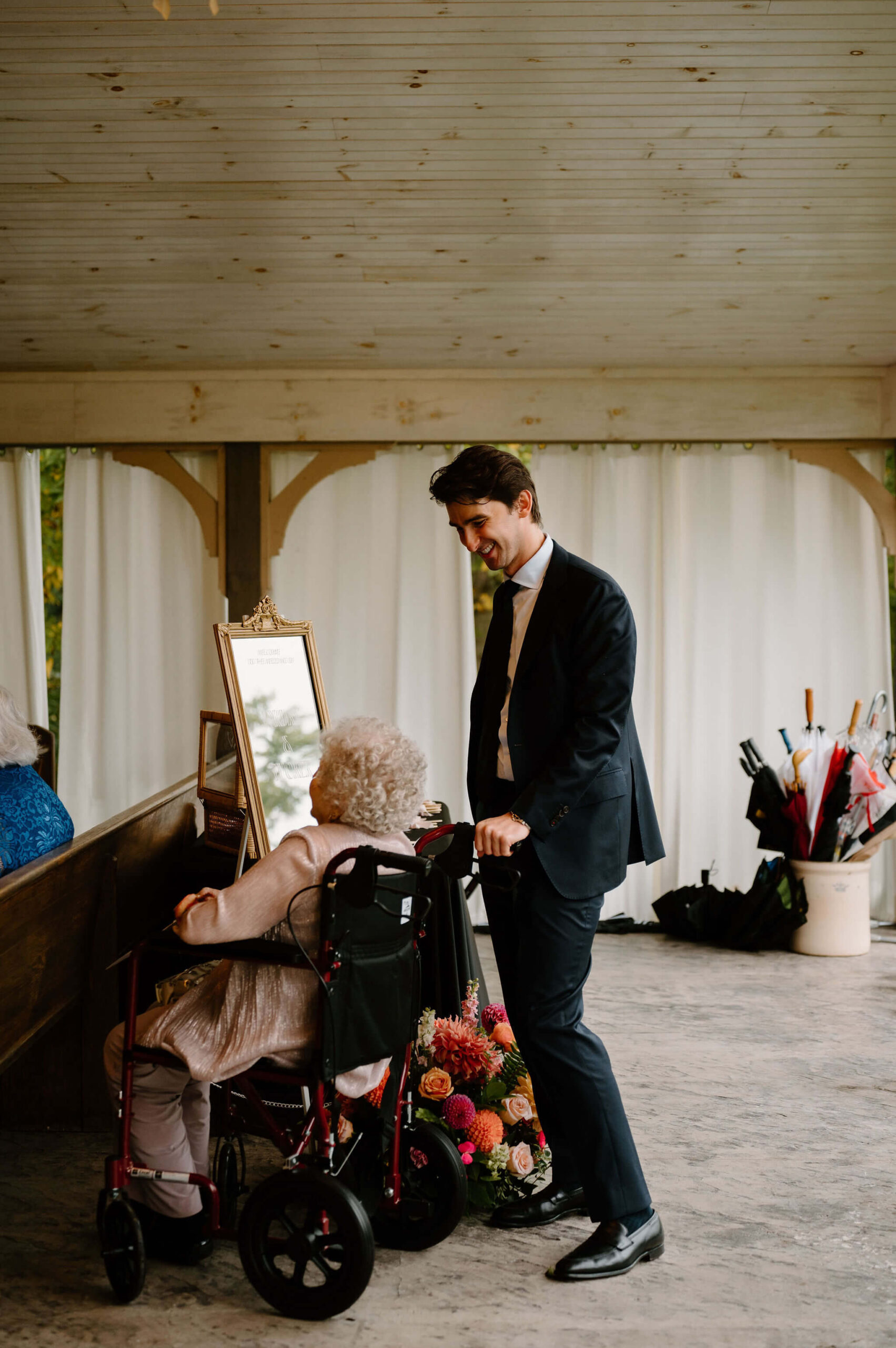 guest helping to push grandmother's wheelchair into the ceremony space