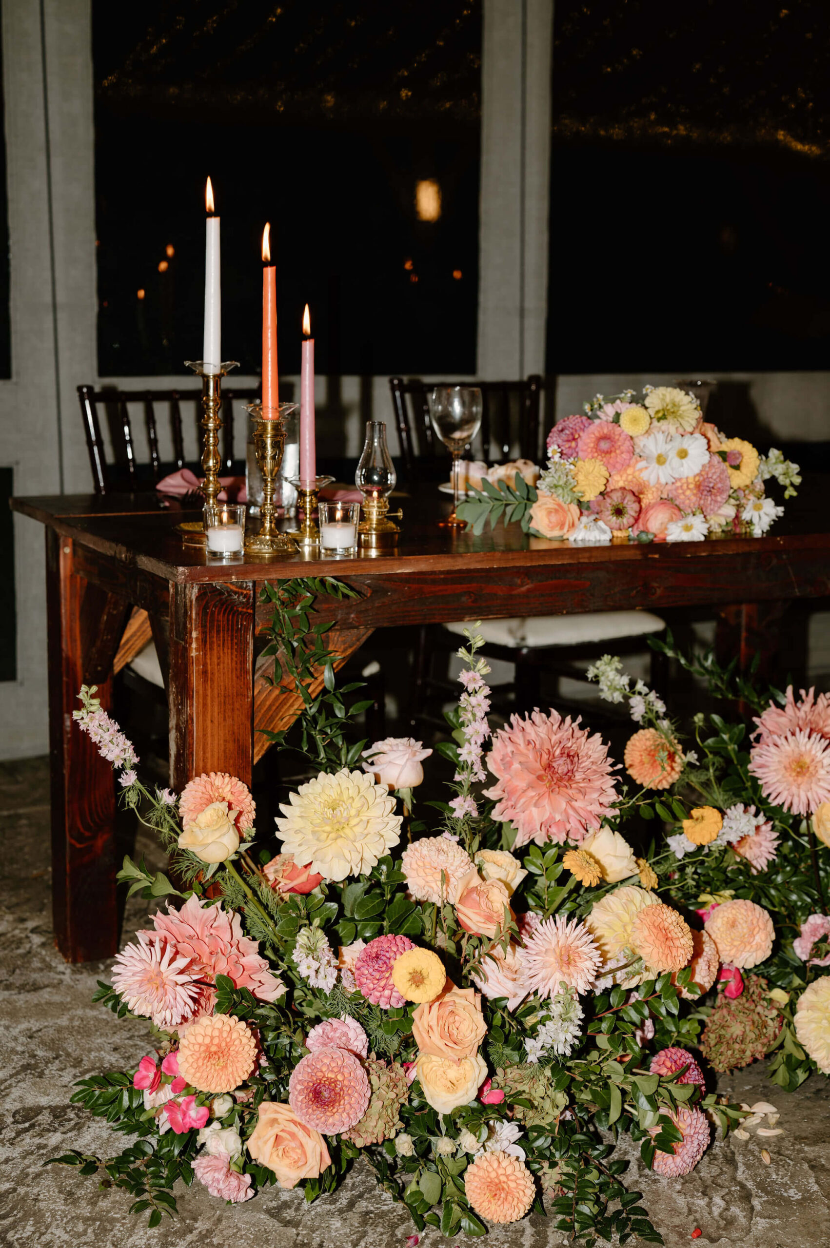 colorful flowers and candlesticks for a sweetheart table at this tented diy wedding reception