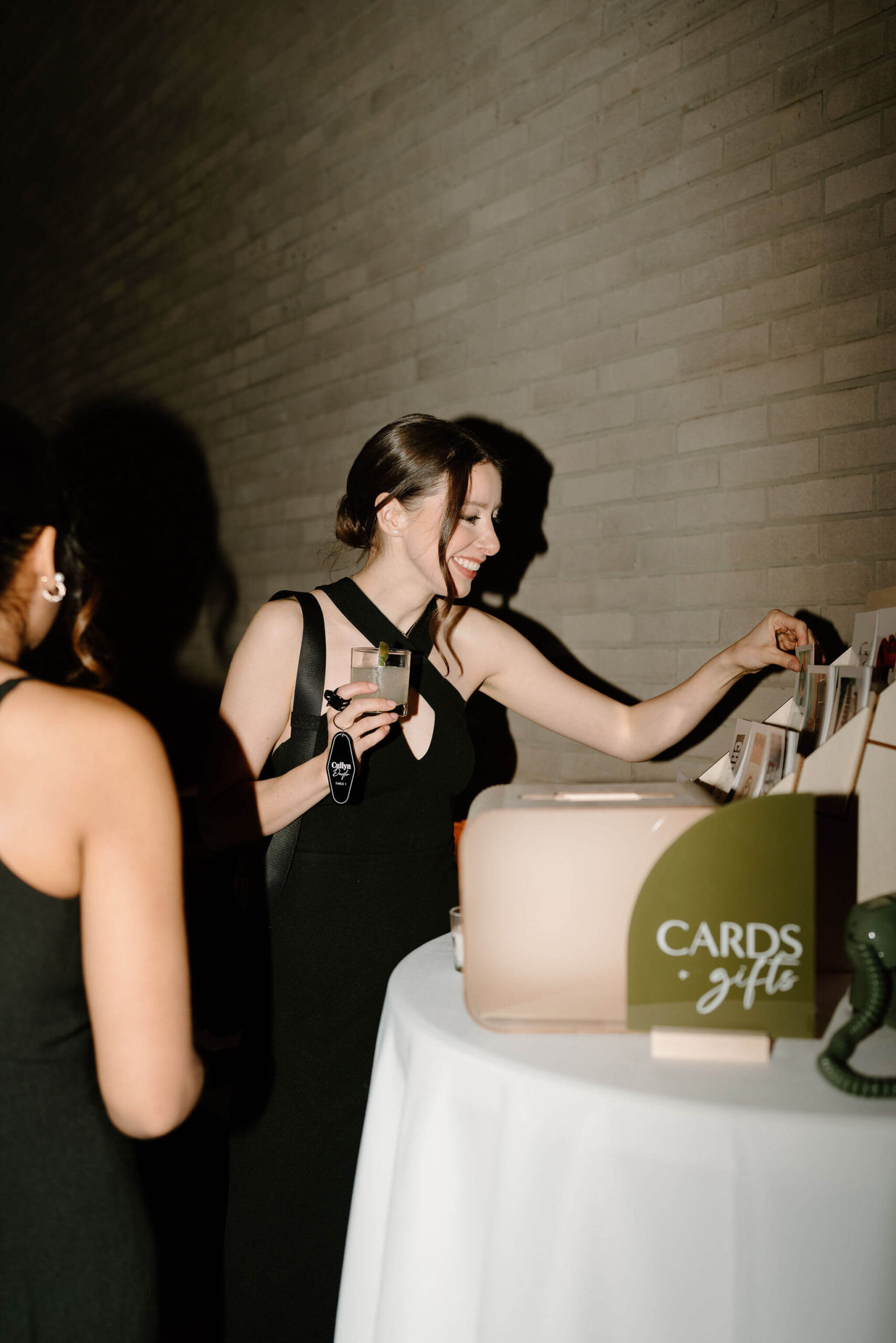 guest picking out a post card from the post card display stand, smiling