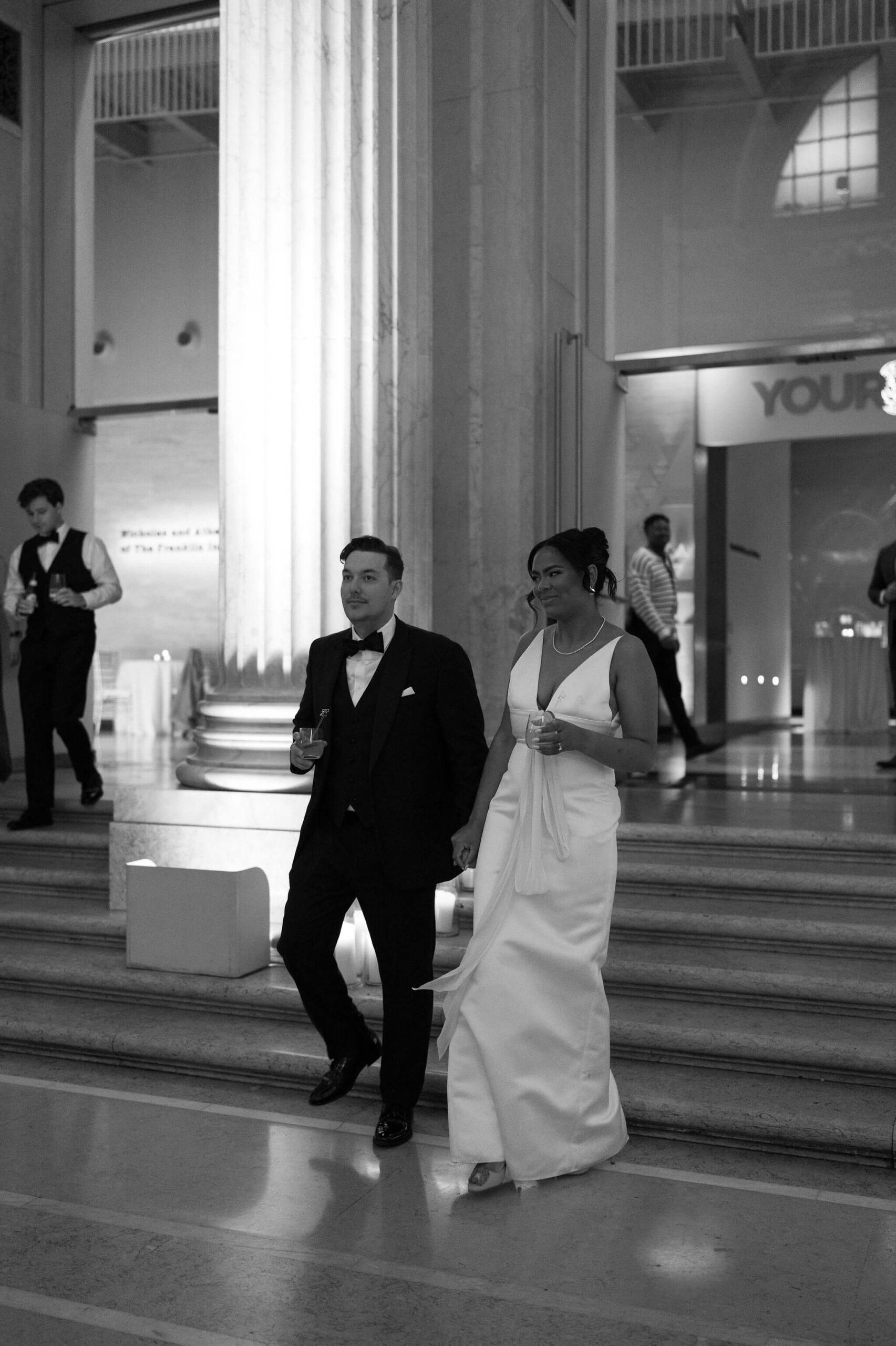 black and white image of bride and groom entering their reception space for the first time