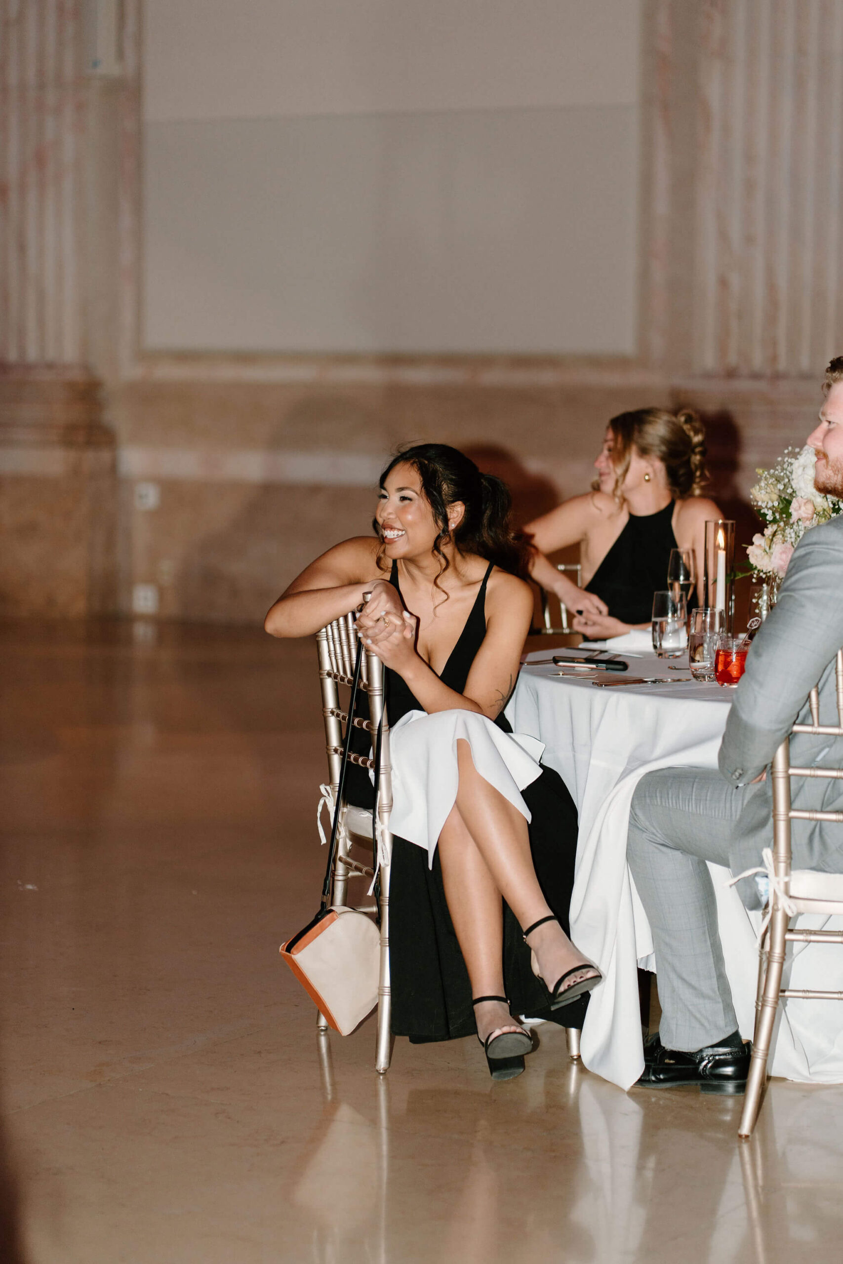 a guest smiling widely during teh formalities at a wedding reception