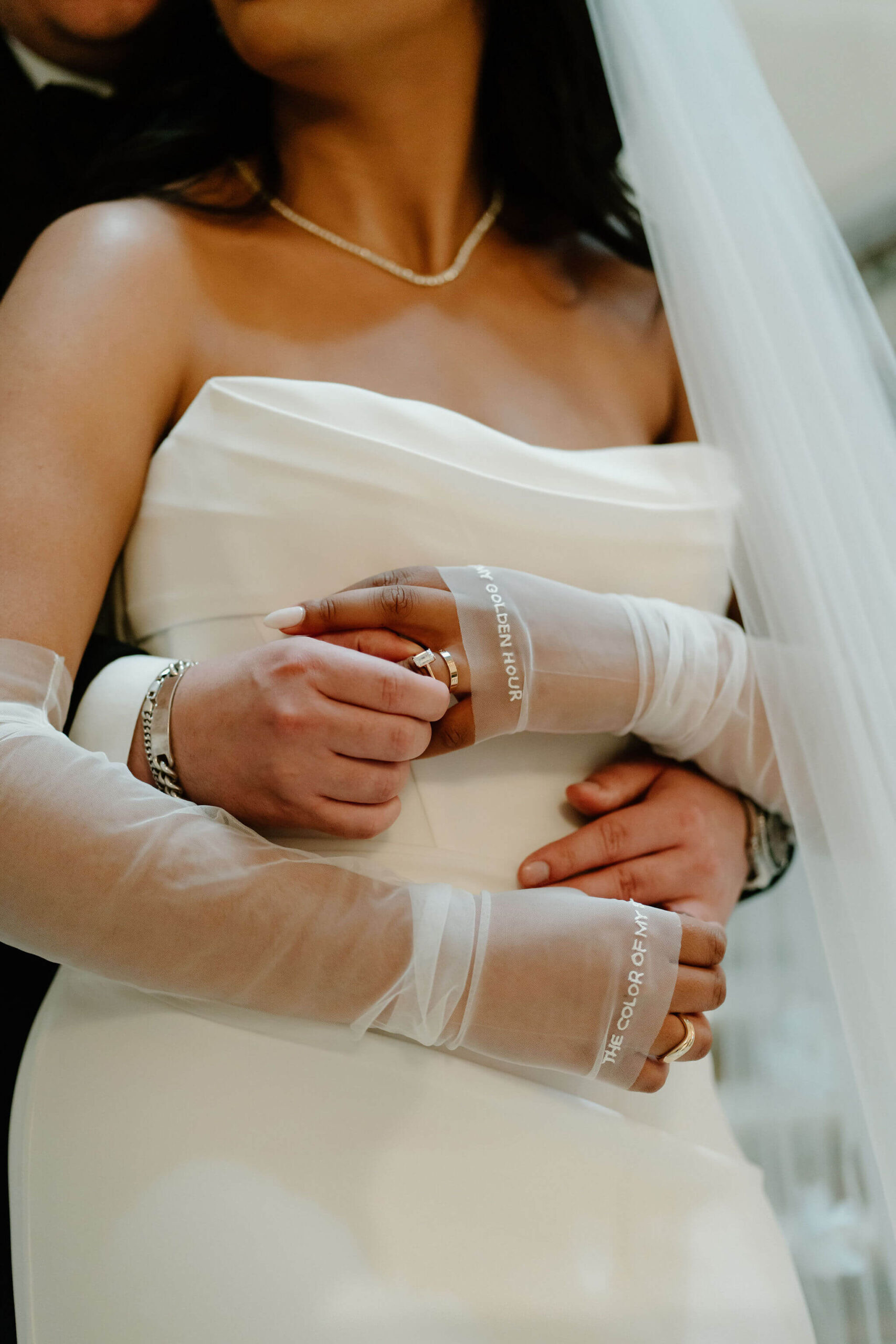 close up of bride and groom's hands reaching around to place their wedding bands on each others fingers