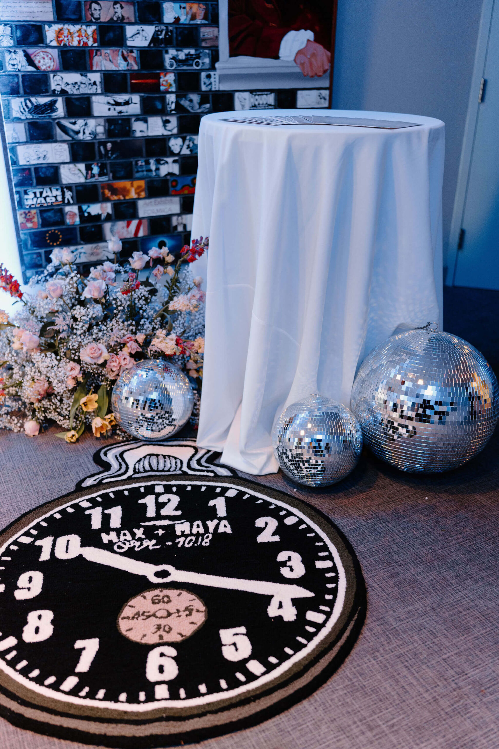 a carpet depicting a clock set to "10:18", which is the date of the wedding, next to a bunch of disco balls