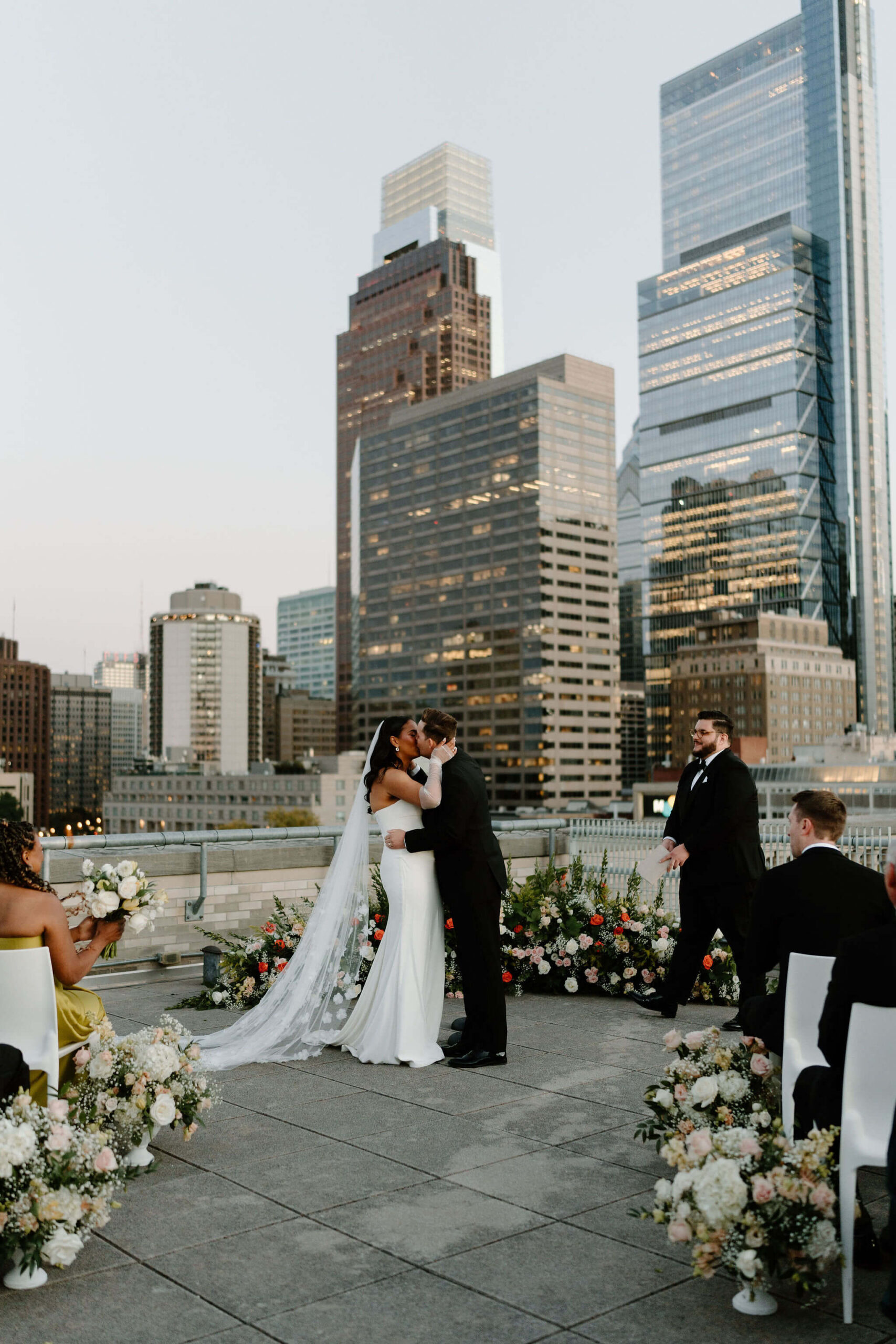 bride and groom kissing at the end of their rooftop franklin institute wedding ceremony at sunset in Philadelphia