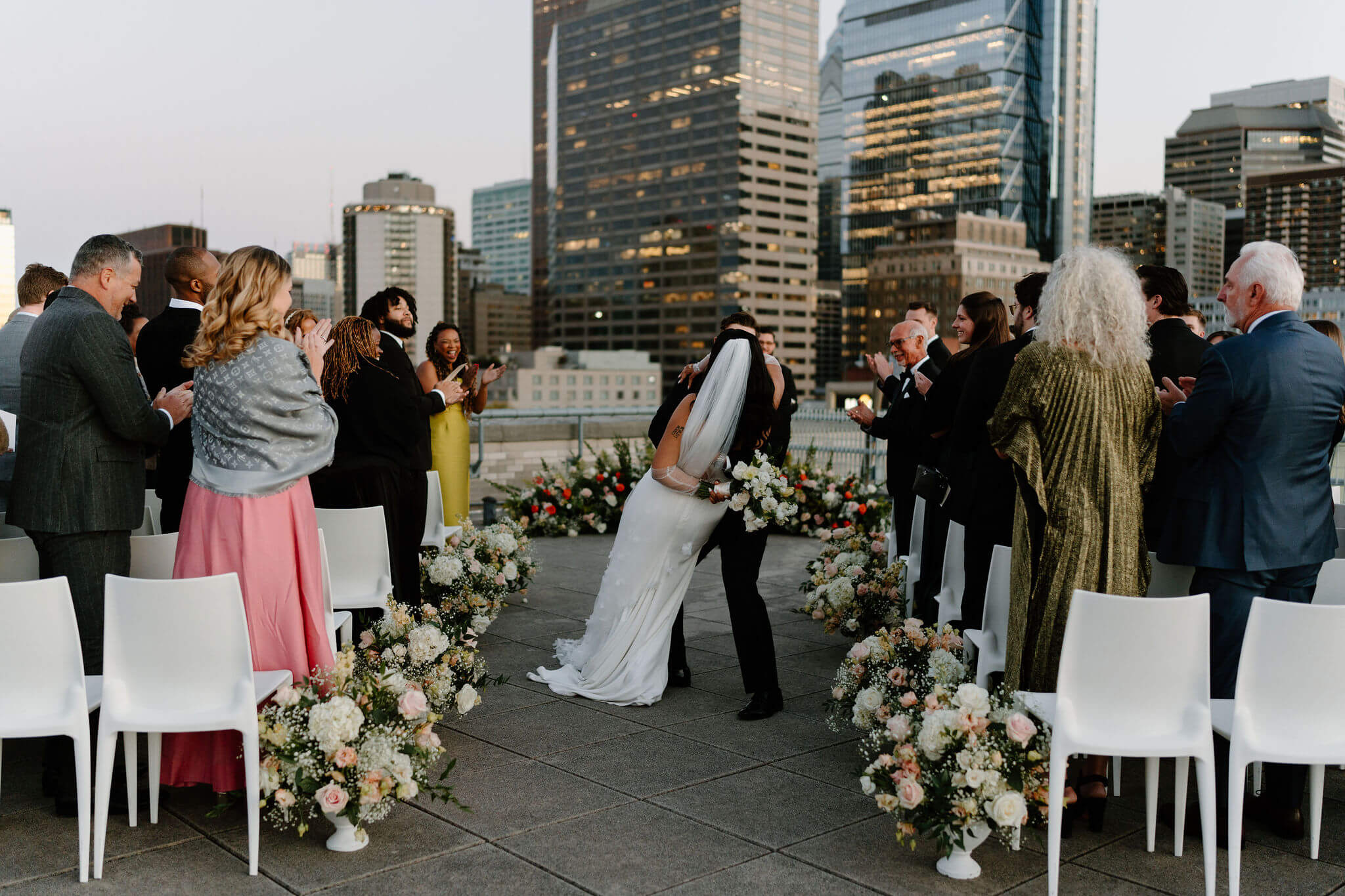 groom dipping bride as they walk down the aisle after their rooftop franklin institute wedding ceremony