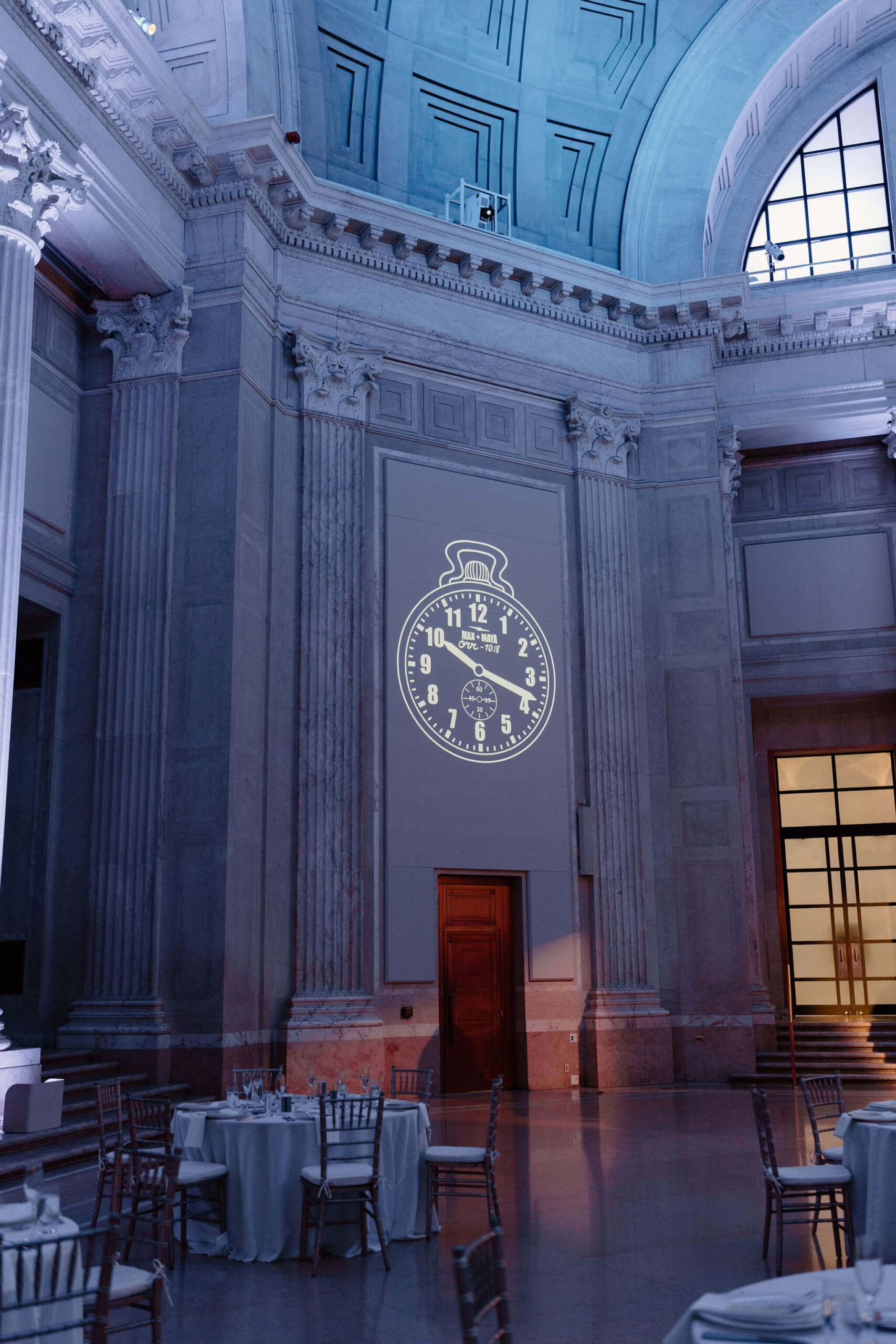 a franklin institute wedding reception, featuring a large clock projected onto the wall