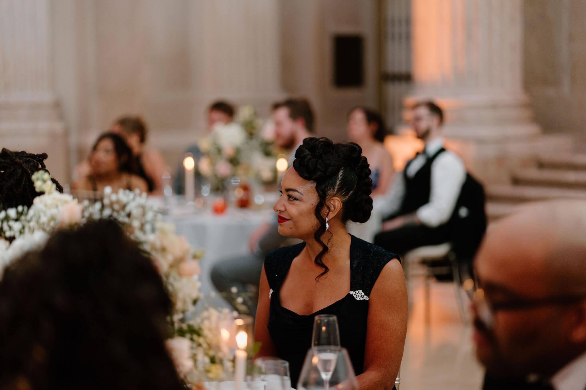 a guest smiling during the formalities at a wedding reception