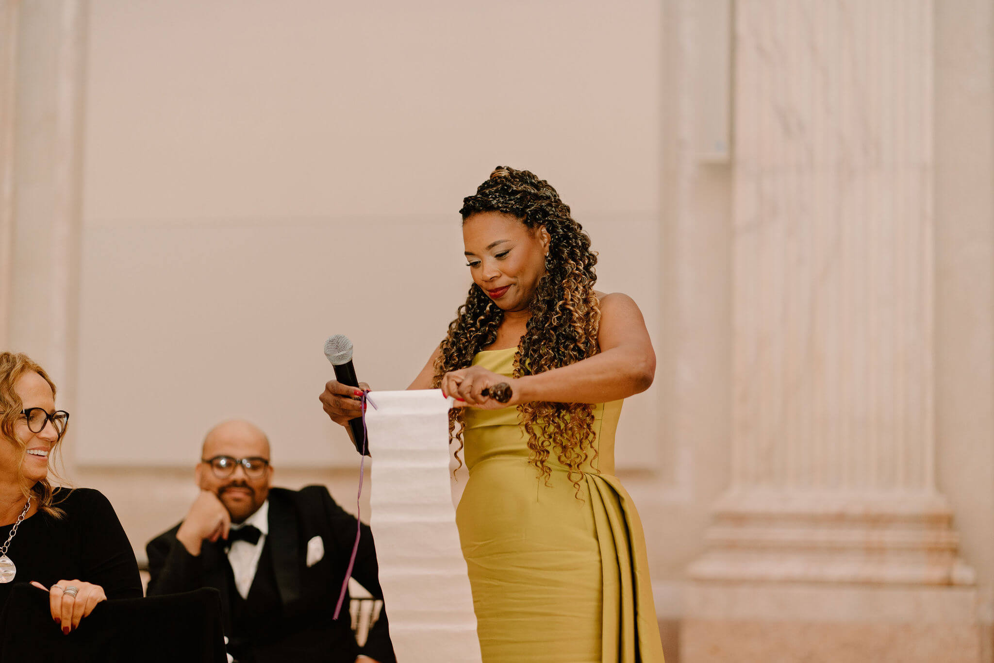 mother of the bride unfurling a scroll  for a speech at her daughter's wedding reception