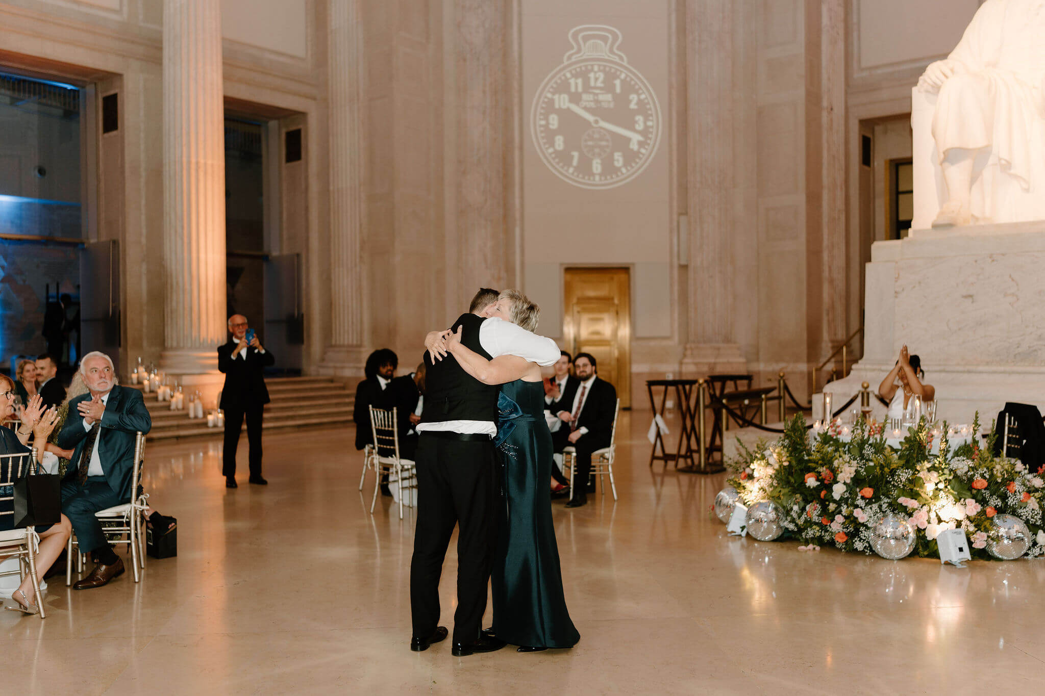 groom and his mother hugging during their mother/son dance at a wedding reception