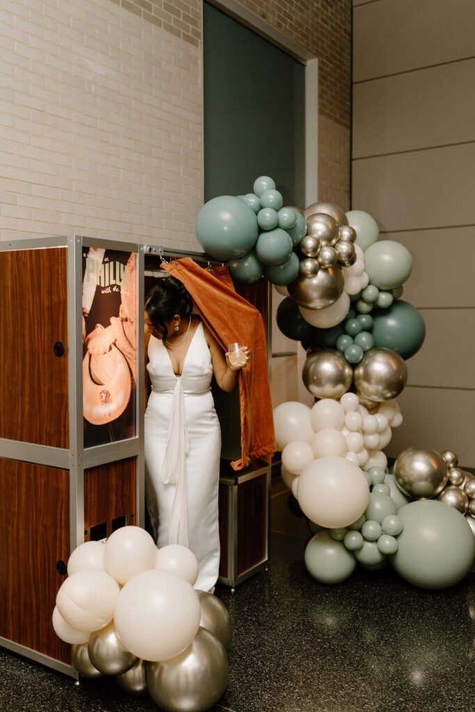 bride exiting the photo booth during her wedding reception