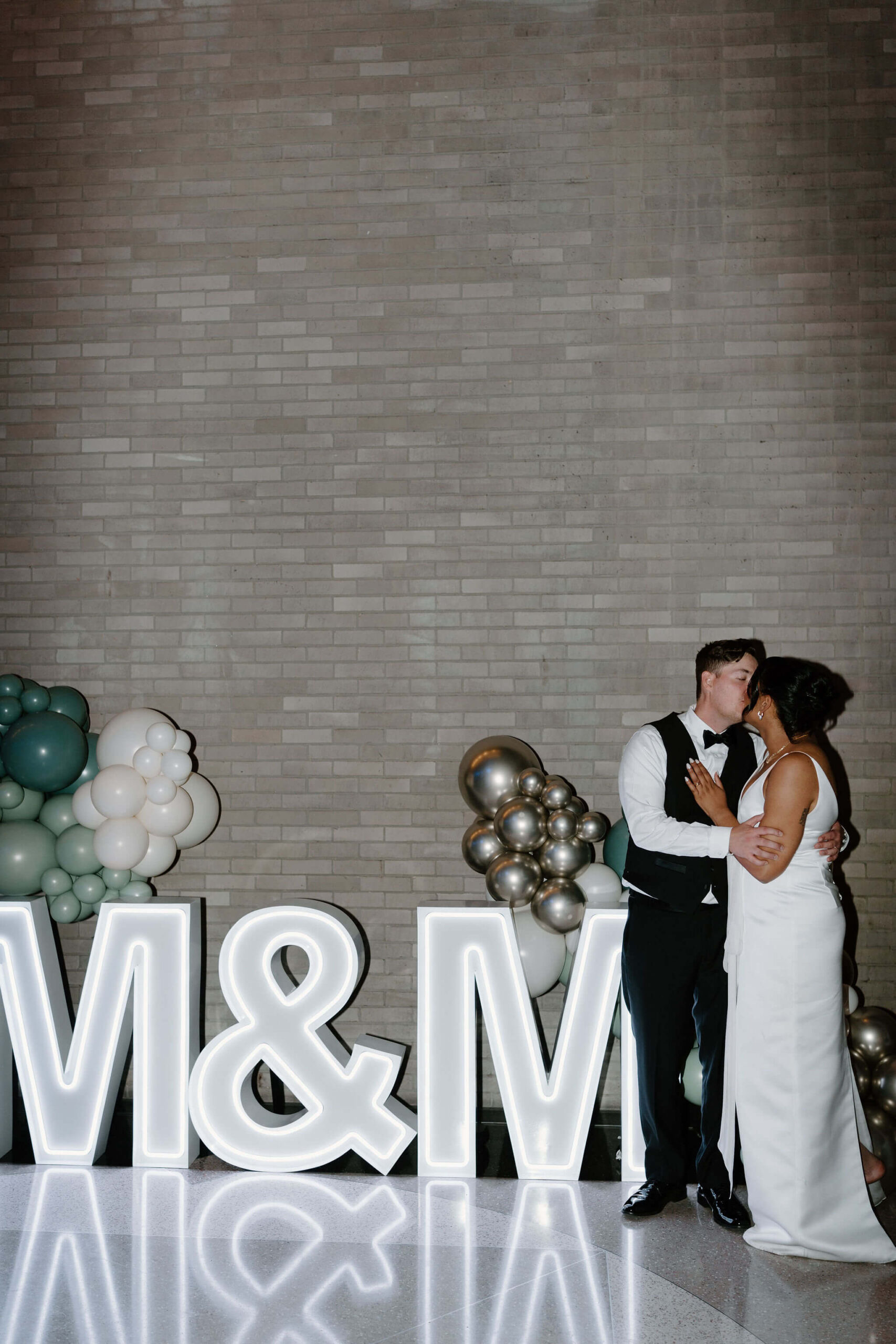 bride and groom kissing in front of the large LED "M&M" Sign