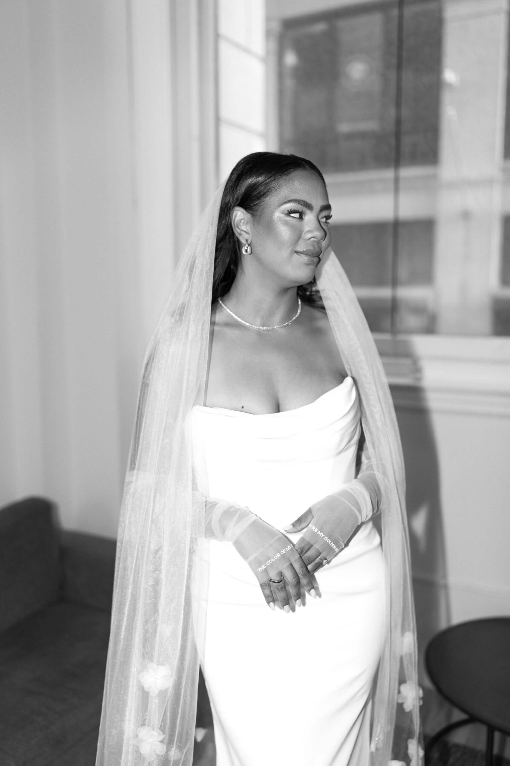 black and white image of the bride in her wedding gown, smiling softly off camera