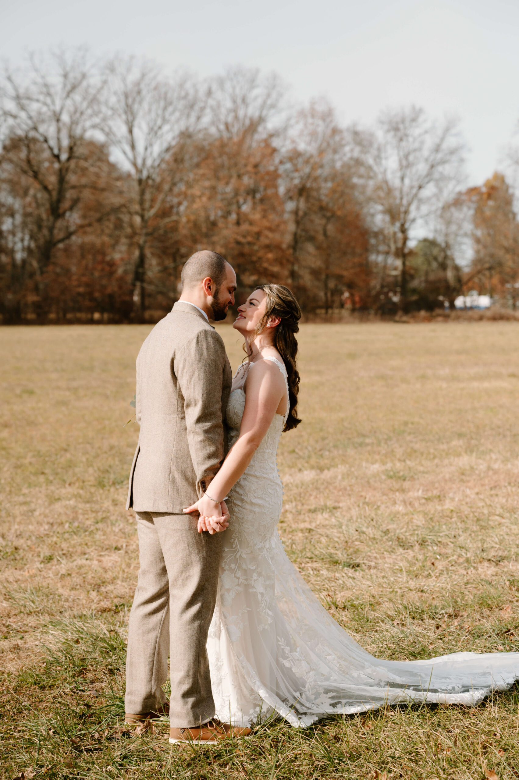 bride and groom holding hands and smiling at each other during their first look on their wedding day