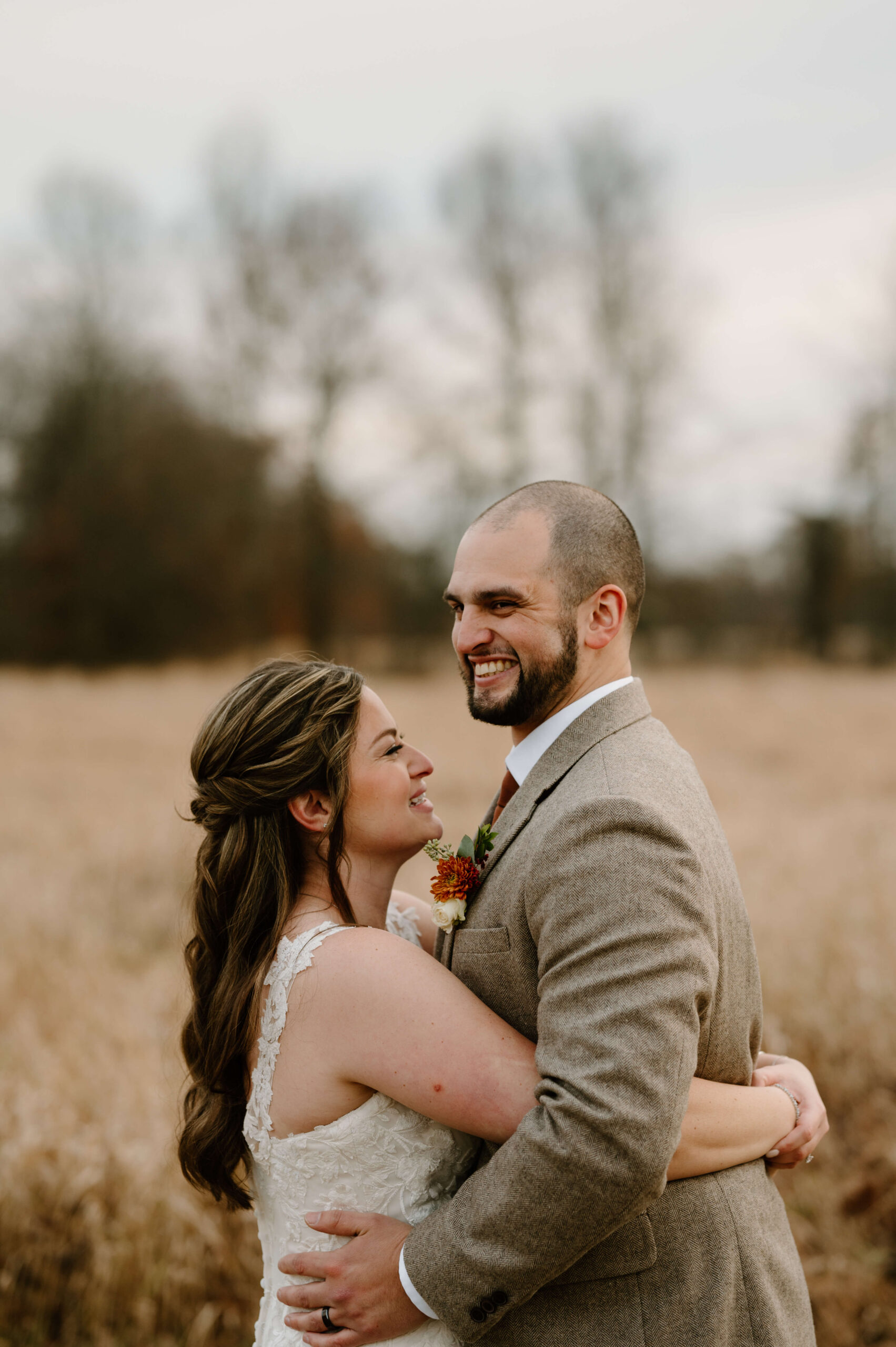 bride and groom embracing and laughing during sunset photos