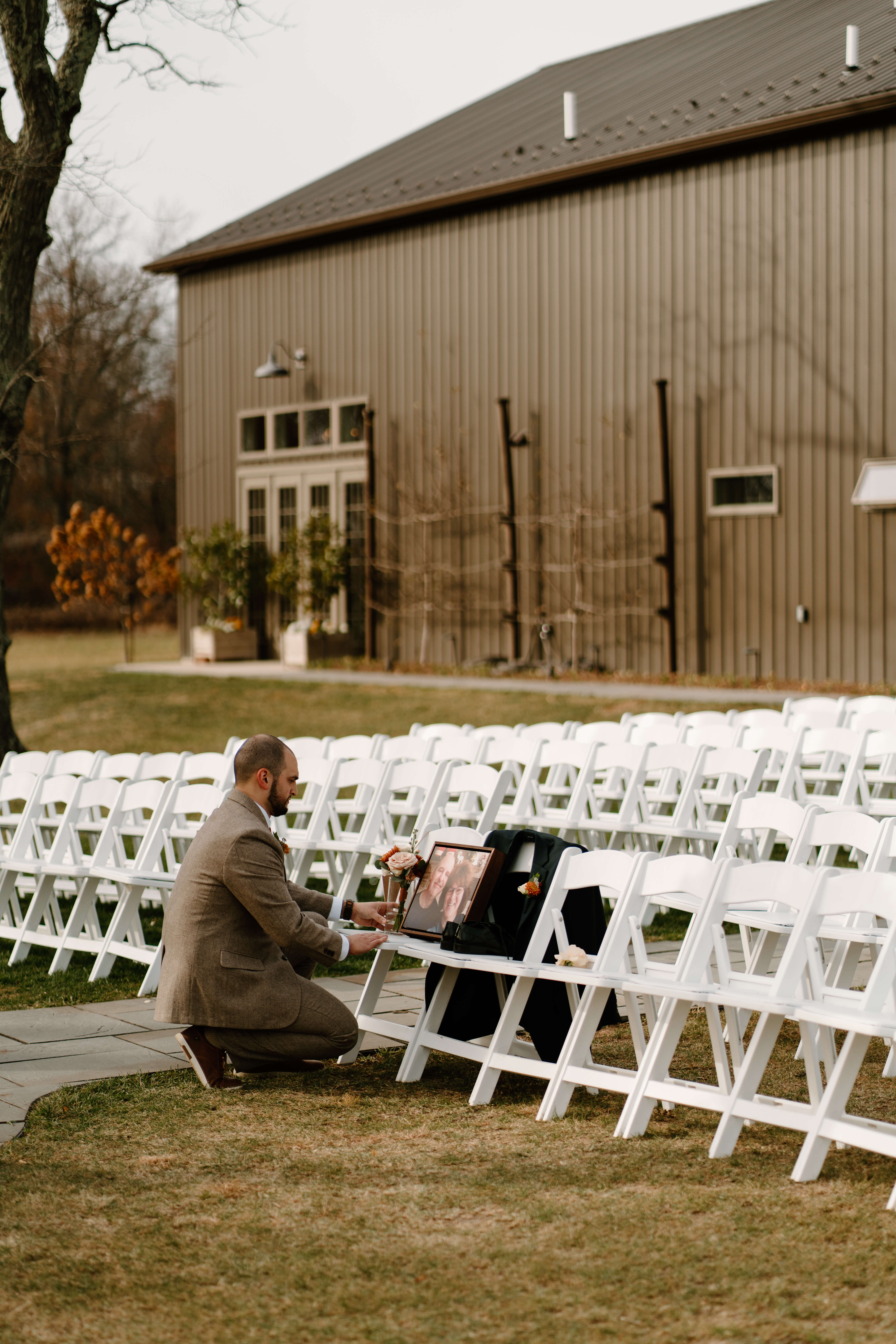 groom placing a memorial of his late parents on their reserved seats prior to his wedding ceremony