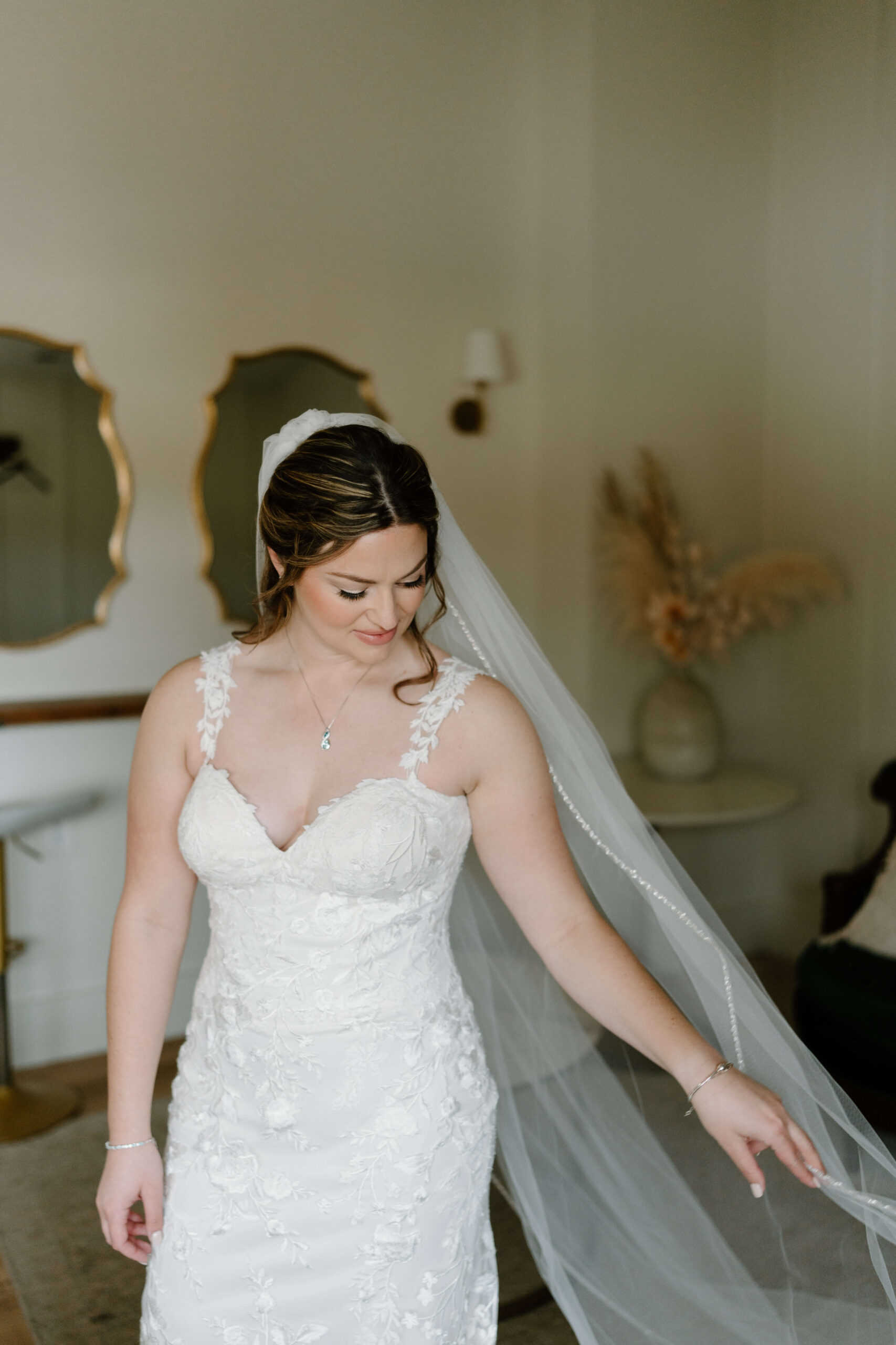 bride in bridal suite, toying with her cathedral-length veil