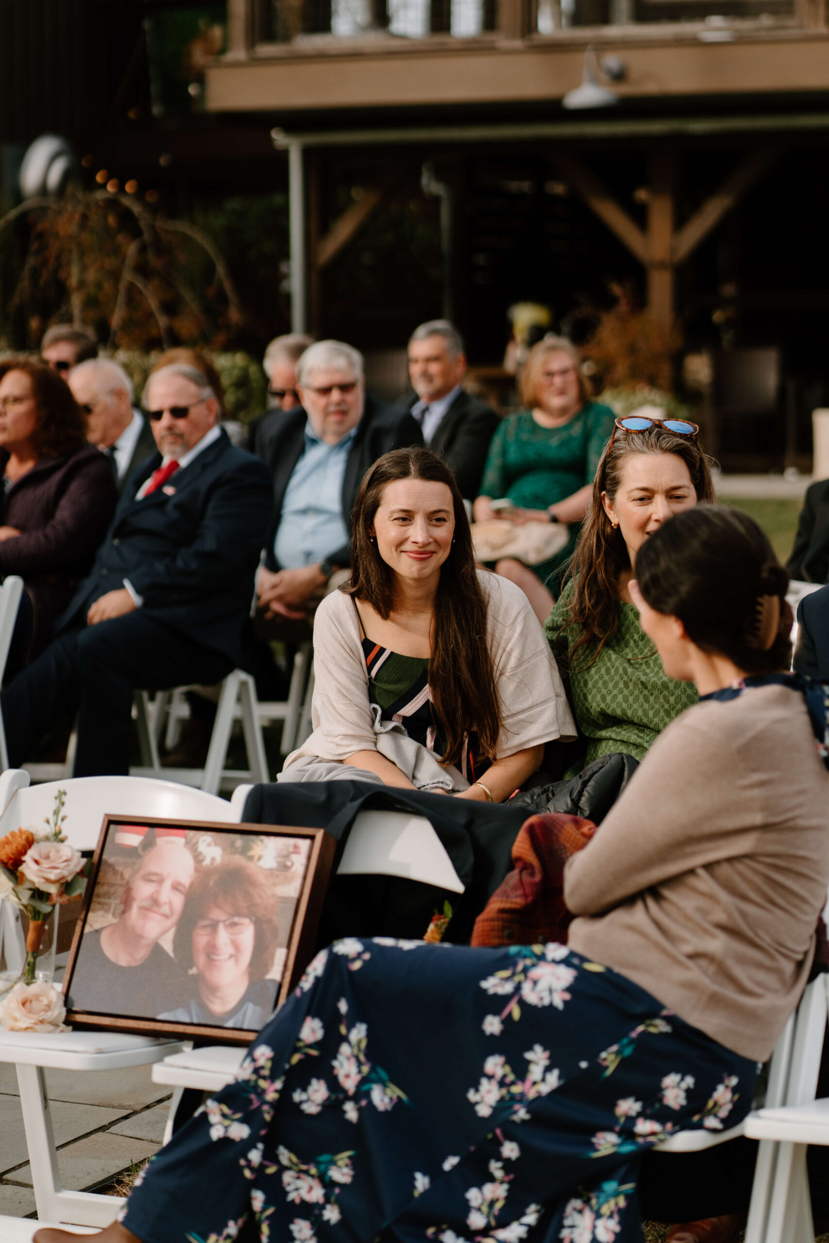 guests seated at wedding ceremony, talking together