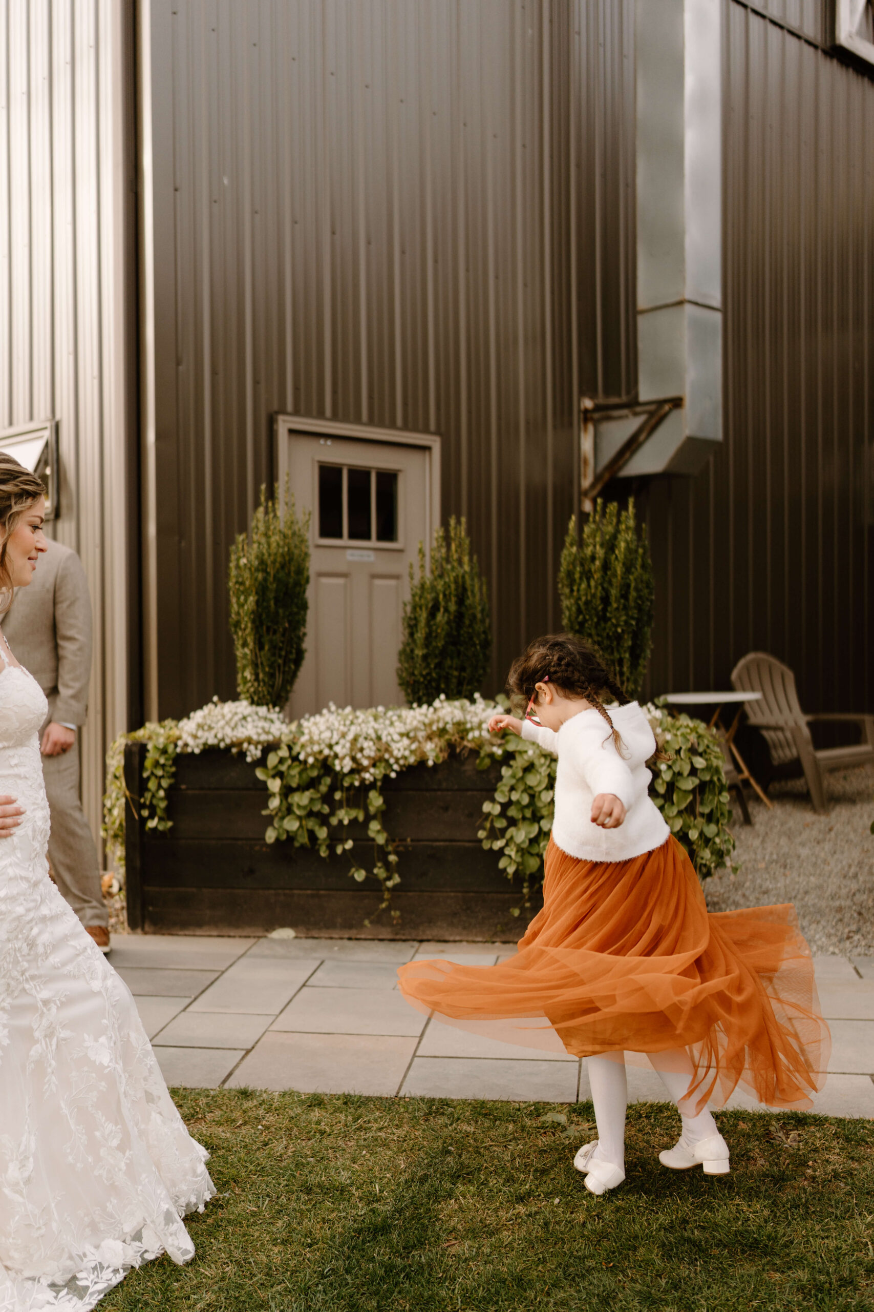 bride's niece spinning around in an orange tulle dress