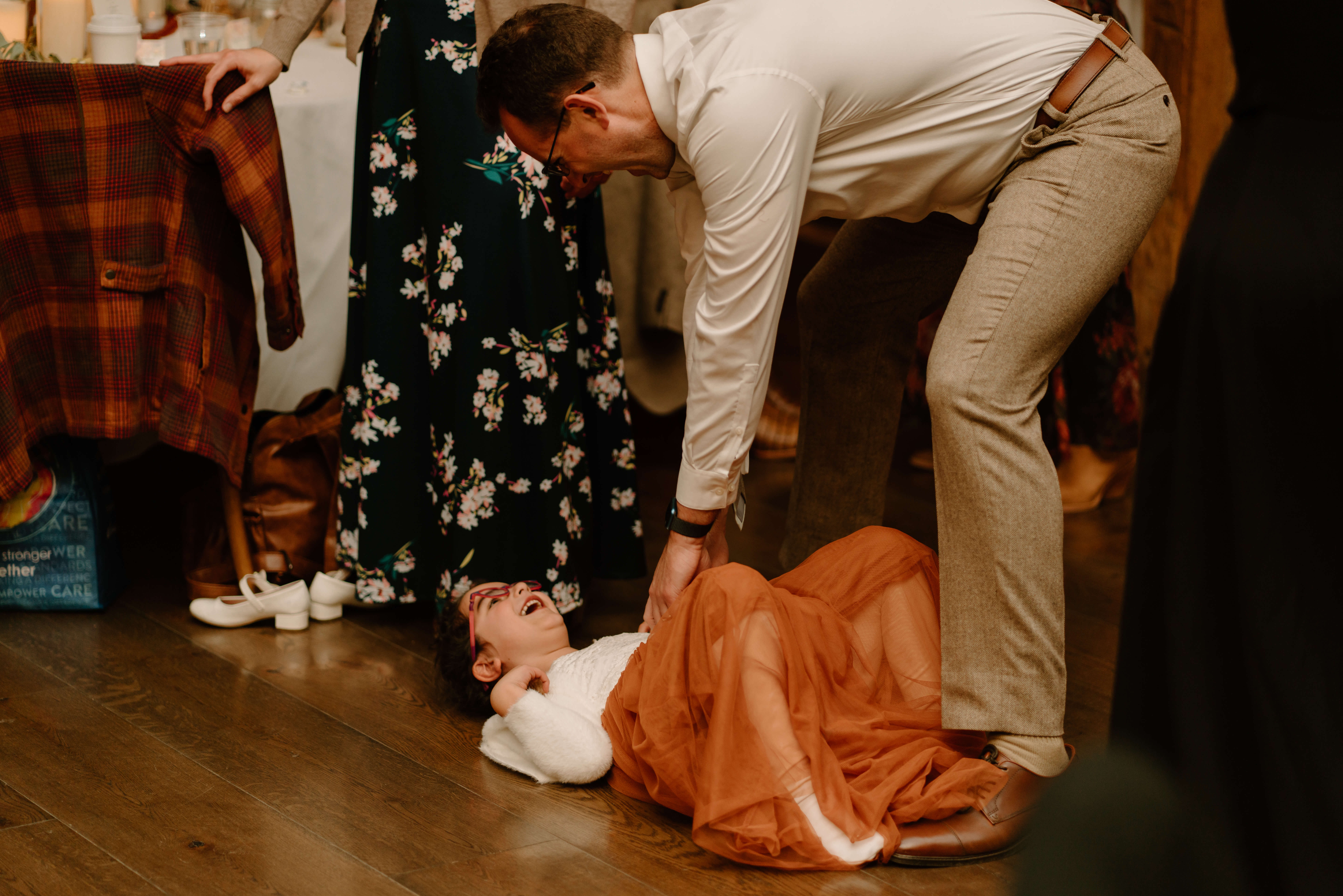 niece of the groom giggling wildly while laying on the floor during wedding reception