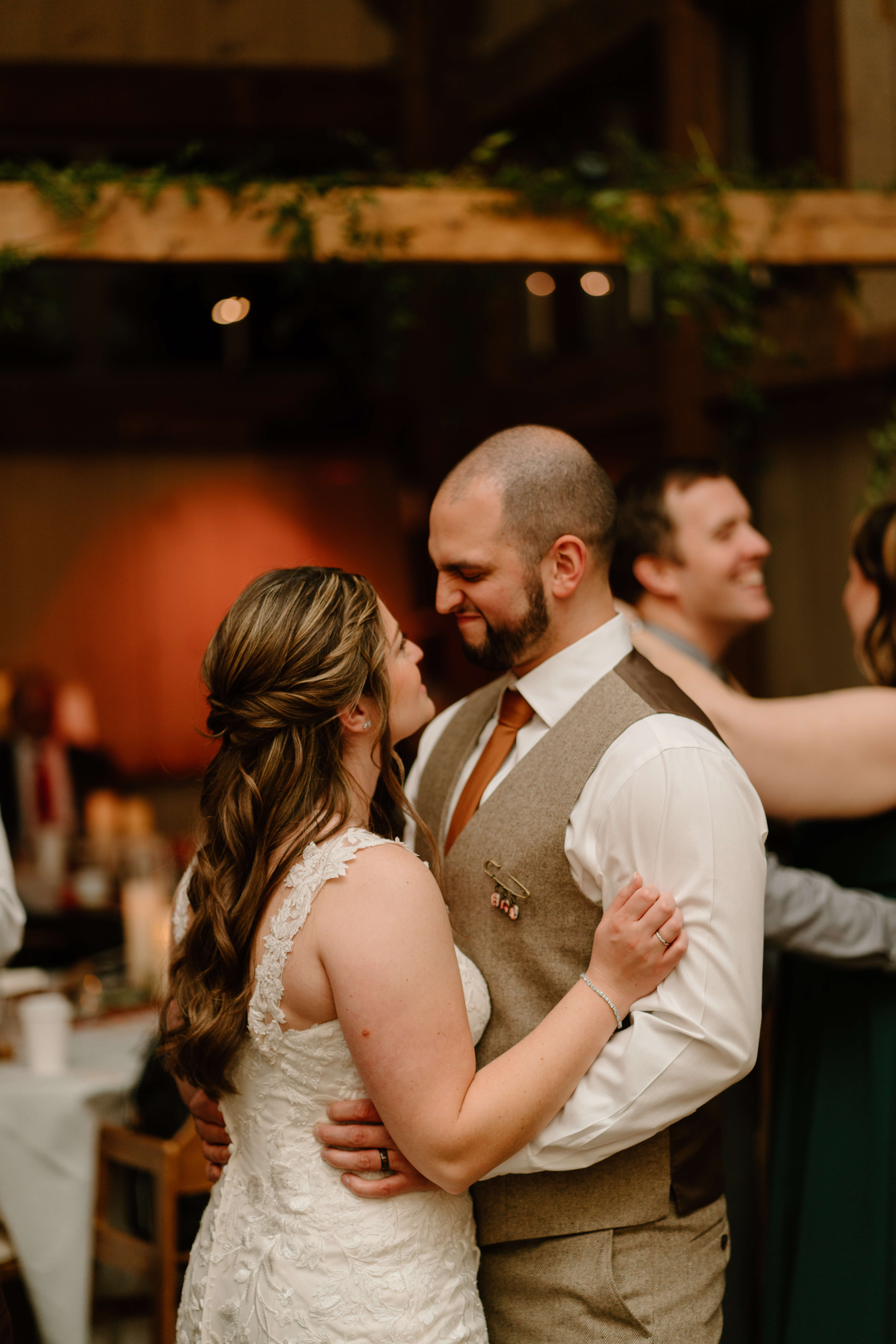 bride and groom smiling at each other while slow dancing at their wedding reception